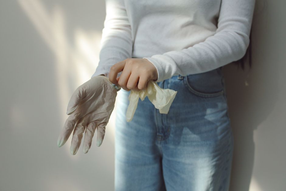 Close-up of a person putting on latex gloves, emphasizing hygiene and safety.